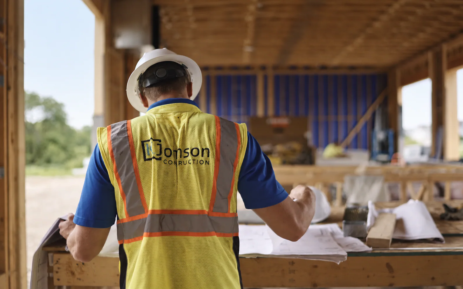 K. Johnson Construction team member reviewing plans on a construction site
